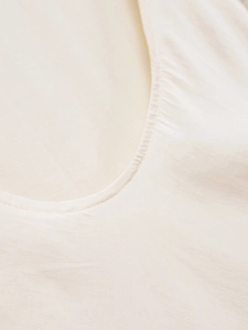 Detailed close-up of the ivory backless dress neckline showing fine stitching and fabric