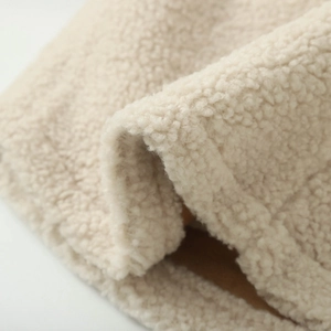 Gros plan sur la texture du tissu polaire sherpa doux d'un sweat à capuche beige