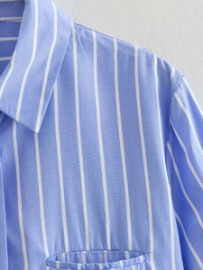 Detailed view of the striped button-down shirt collar and a front square pocket
