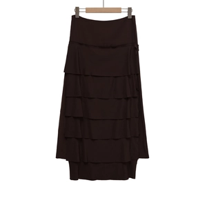 Detail of deep brown tiered midi skirt featuring layered ruffle design and soft texture