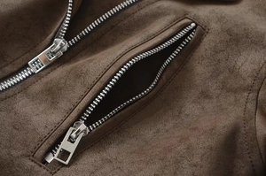 Detail of silver metal zipper and soft brown faux suede texture on a biker jacket