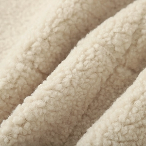 Gros plan sur la texture bouclée et douce de la polaire sherpa crème de haute qualité