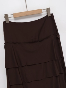 Detailed view of dark brown tiered midi skirt fabric texture and three-layer ruffles