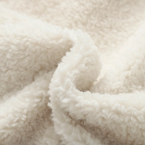 Close-up of warm cream faux shearling fabric texture for casual stand-collar coats