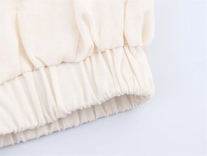Detail view of elastic ribbed hem on a cream-white cotton linen casual jacket for women