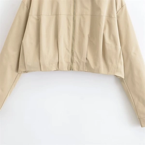 Detail der khakifarbenen Jacke mit Faltenrevers, Windschutzstoff und Metallreißverschluss