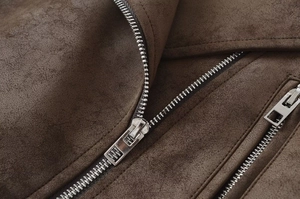 Detailed close-up of premium brown faux suede fabric and silver metal zipper on the jacket