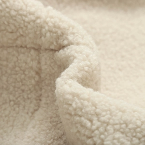 Gros plan sur la texture sherpa blanc crème et les détails de couture du sweat à capuche