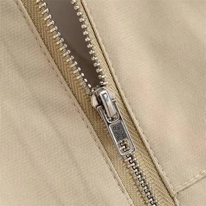 Makroaufnahme von hochwertigem Silber-Metallreißverschluss und khakifarbenem Twill-Gewebe