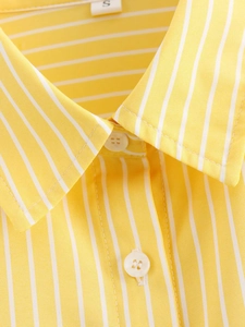 Detail of yellow and white striped shirt collar with white resin buttons and size label