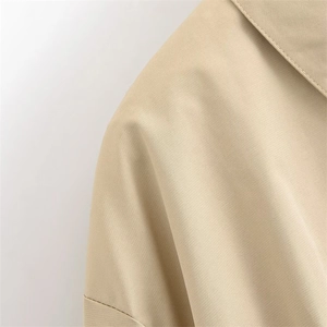 Detail von Revers und Schulter an beiger Plissee-Jacke mit Twill-Struktur und Nähten