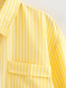 Close-up of a yellow striped shirt showing the collar, front pocket, and fabric texture