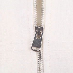 Close-up of high-quality silver metal zipper on a white minimalist casual jacket