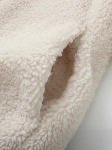 Creamy white sherpa fleece jacket featuring a high collar and side pocket detail