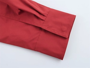 Detailansicht der plissierten Manschette einer roten Jacke mit feiner Ziernaht