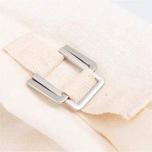 Detailed view of cream-colored casual jacket with silver metal adjustment buckle