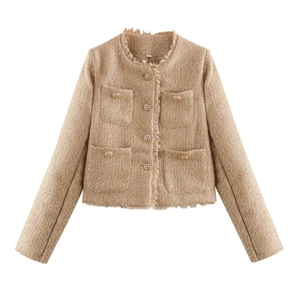 Macro detail of gold tweed jacket featuring metallic threads and ornate gold buttons