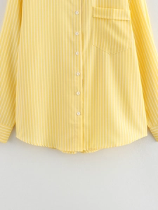 Detailed view of yellow and white striped shirt with cotton texture and front pocket