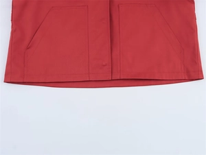 Detailansicht des roten Jackensaums mit symmetrischen Eingrifftaschen und Nähten
