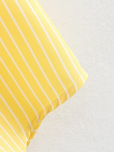 Close-up of yellow and white striped fabric showing fine texture and neat stitching details