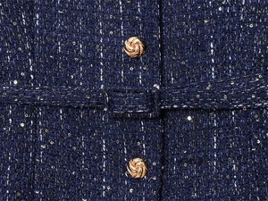 Detail of dark blue tweed jacket showing gold buttons and sequins texture