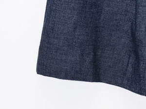 Detailed close-up of dark blue denim fabric texture and stitching on vest shorts set