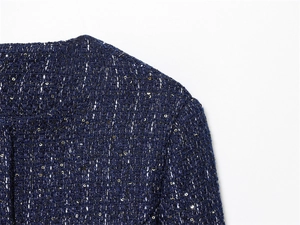 Detailed macro view of navy blue tweed jacket fabric with sequins and metallic fibers