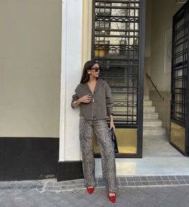 Street style view of a brown cropped zipper jacket and leopard print wide-leg pants