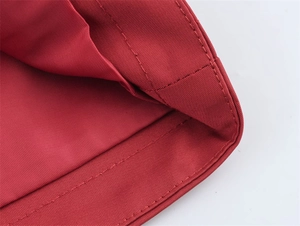 Makro-Detail des roten Twill-Stoffs der Jacke mit hochwertiger Doppelnaht-Verarbeitung