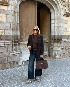 Detail of a brown suede blazer paired with vintage sneakers and a large tote bag