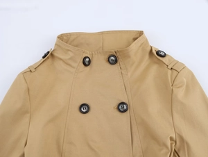 Detail of khaki trench coat collar featuring shoulder epaulettes and black double-breasted buttons