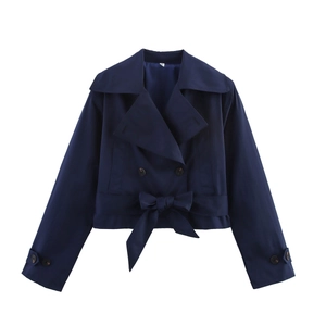 Detail of navy double-breasted trench coat with bow belt and cuff straps