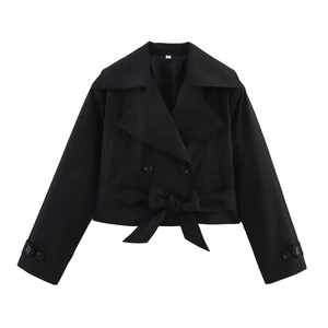 Detailed view of the double-breasted collar and bow tie belt on a black trench coat