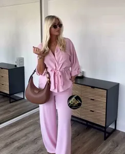 Detailed view of pink two-piece set featuring a drawstring waist shirt and wide-leg trousers