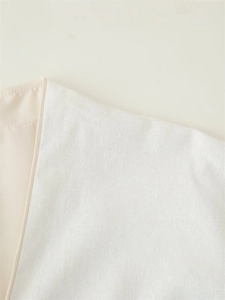 Close-up of white embroidered kimono jacket fabric showing fine texture and sewing detail