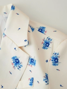 Detail eines bedruckten Blazers mit Reverskragen und cremefarbenem Webstoff mit Blumen