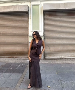 Detailed view of dark brown knitted vest top with gold buttons and pleated maxi skirt
