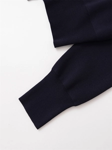 Gros plan sur un tricot bleu marine avec poignets côtelés détaillés et texture dense