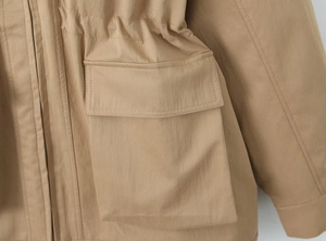 Detail of khaki functional jacket featuring large flap pocket and adjustable waist drawstring