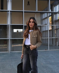 Dettaglio giacca in tweed marrone con bottoni dorati e borsa in pelle elegante