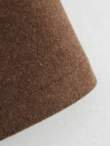 Close-up detail of premium brown wool fabric with precise stitching on a women's jacket
