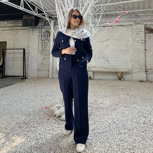 Modella all'aperto con giacca in tweed blu navy con bottoni dorati e pantaloni larghi