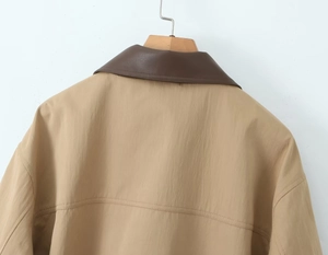 Detail of the khaki windbreaker featuring a brown leather collar and neat stitching back view