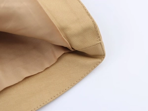 Detail shot of khaki trench coat fabric showing neat stitching and smooth inner lining