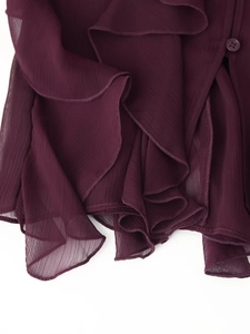 Macro-detail van de wijnrode chiffon stof met ruches en een bijpassende harsknoop