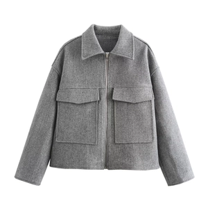 Detail of grey wool-blend jacket showing oversized flap pockets and silver zipper
