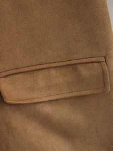 Detailed macro view of the brown suede jacket pocket with clean double stitching