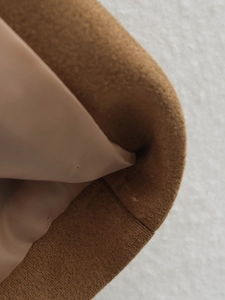 Detailed close-up of brown suede blazer lining with smooth satin finish and fine stitching