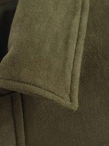 Macro shot of olive green suede jacket collar showing durable double-stitched sewing details