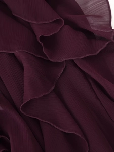 Gedetailleerd zicht op gelaagde ruches met fijne lockranden op bordeaux chiffon stof